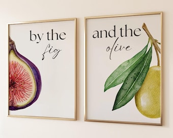 May include: Two framed art prints with gold frames. One features a watercolor fig with the text "by the fig." The other shows an olive branch with the text "and the olive."
