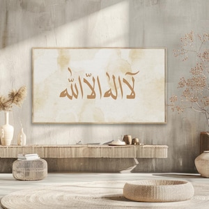 Puede incluir: Una impresión sobre lienzo beige con un fondo de acuarela marrón. La impresión presenta la frase árabe "La ilaha illa Allah" en caligrafía marrón.