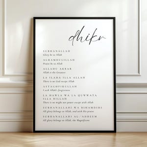 Könnte beinhalten: Gerahmter Druck mit schwarzem Rahmen. Das Wort "dhikr" steht in Schreibschrift oben. Darunter ist eine Liste arabischer Sätze und ihrer englischen Übersetzungen auf weißem Hintergrund dargestellt.