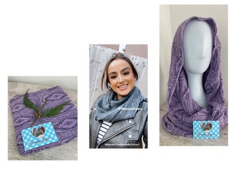 May include: A purple knitted infinity scarf with a textured cable pattern. The scarf is displayed folded and draped over a mannequin head. A small rectangular card with a blue checkered border and the text Yammys Alpaca is included.