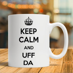 May include: White ceramic mug with a black crown and the text "Keep Calm and Uff Da" printed on it.