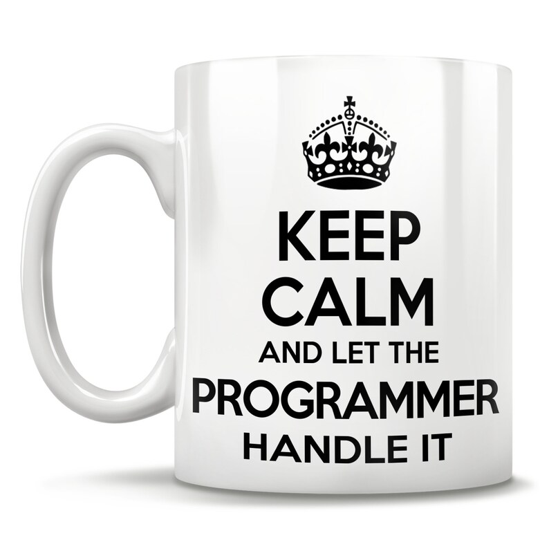 Op de afbeelding: Een witte keramische mok met een zwarte kroon en de tekst "Keep Calm and Let the Programmer Handle It."