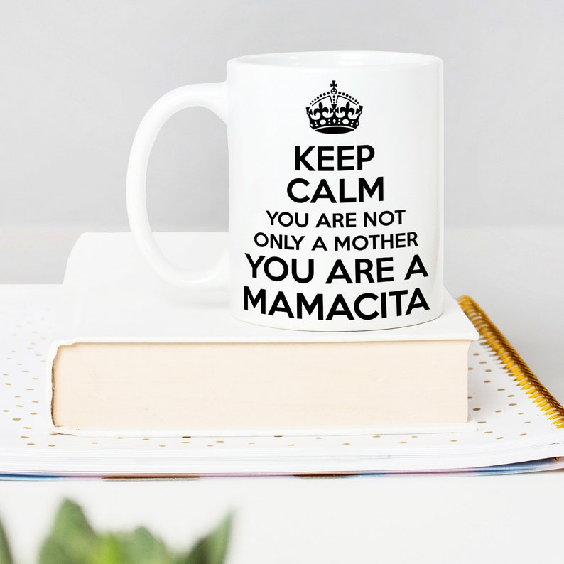 May include: White ceramic mug with a black design that reads "Keep Calm You Are Not Only A Mother You Are A Mamacita". The mug has a black crown graphic at the top of the design.