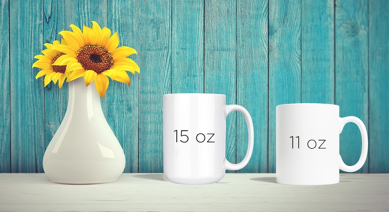May include: A white ceramic vase holds bright yellow sunflowers. Two white mugs are displayed, one labeled "15 oz" and the other "11 oz". The background is a teal-colored wooden wall.