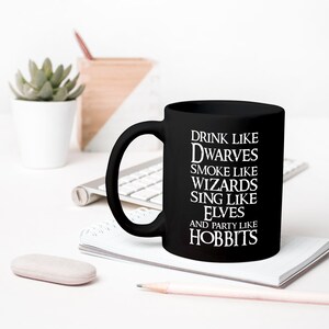 May include: Black ceramic mug with white text that reads "Drink like Dwarves, Smoke like Wizards, Sing like Elves, and Party like Hobbits".