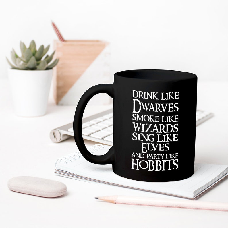 May include: Black ceramic mug with white text that reads "Drink like Dwarves, Smoke like Wizards, Sing like Elves, and Party like Hobbits".