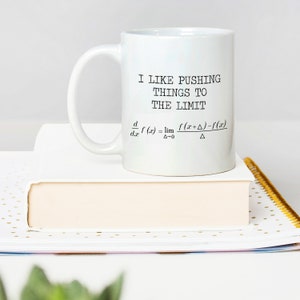May include: White ceramic coffee mug with a black graphic that says "I like pushing things to the limit" and a mathematical formula for the derivative of a function.