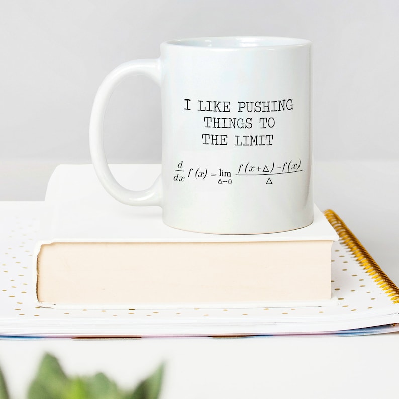 May include: White ceramic coffee mug with a black graphic that says "I like pushing things to the limit" and a mathematical formula for the derivative of a function.