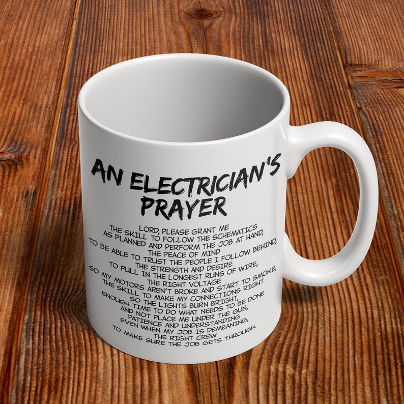 May include: White ceramic mug with a black printed text that reads "An Electrician's Prayer" and a prayer. The mug has a curved handle and is set against a wooden background. A great gift for electricians.