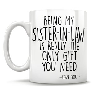 Puede incluir: Taza de caf&eacute; de cer&aacute;mica blanca con texto negro que dice "Ser mi cu&ntilde;ada es realmente el &uacute;nico regalo que necesitas -Te quiero-"