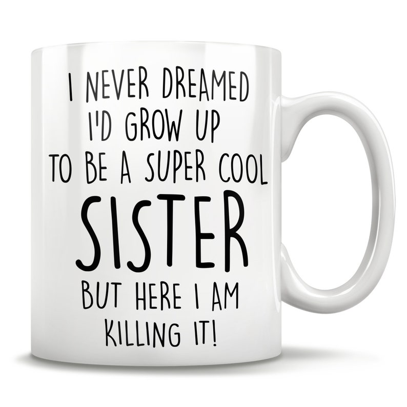 Puede incluir: Taza de caf&eacute; de cer&aacute;mica blanca con texto negro que dice "Nunca so&ntilde;&eacute; con crecer para ser una hermana s&uacute;per genial, pero aqu&iacute; estoy, &iexcl;mat&aacute;ndolo!"