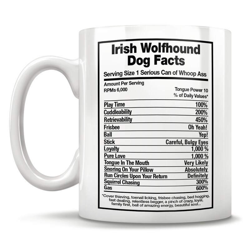 May include: White ceramic coffee mug with a black and white graphic of a humorous Irish Wolfhound dog facts list. The list includes tongue power, play time, cuddleability, retrievability, frisbee, ball, stick, loyalty, pure love, tongue in the mouth, snoring on your pillow, run circles upon your return, squirrel chasing, and gas. The text at the bottom of the graphic reads "Cover thieving, toenail licking, frisbee chasing, bed hogging, fast dealing, relentless begger, a pinch of crazy, loyal, family first, ball of amazing energy, beautiful soul..."