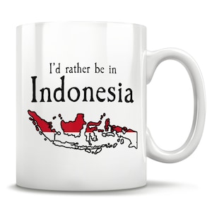 Op de afbeelding: Een witte keramische koffiemok met een zwarte omtrek van de Indonesische archipel en de tekst "I'd rather be in Indonesia". De eilanden zijn gekleurd in de kleuren van de Indonesische vlag, rood en wit.