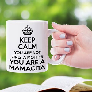 May include: White ceramic mug with a black crown and the text "Keep Calm You Are Not Only A Mother You Are A Mamacita".