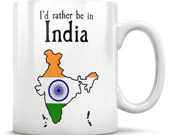 Op de afbeelding: Witte keramische mok met de tekst "I'd rather be in India" boven een kaart van India, gekleurd met de Indiase vlag. De mok heeft een gebogen handvat en is ontworpen voor warme dranken.