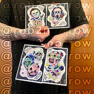 May include: Four tattoo-style art prints featuring horror movie characters. The prints include images of Michael Myers, Ghostface, a skull, a witch, a pumpkin, and a clown with flower-covered eyes. Each print has text at the top and bottom.