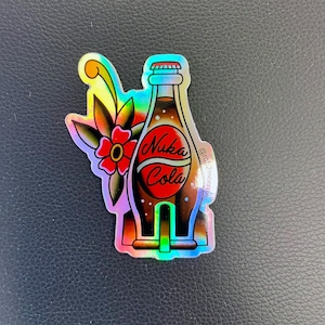May include: A holographic sticker of a Nuka Cola bottle with a red flower and green leaves. The bottle is brown with a red label that says "Nuka Cola". The sticker has a rainbow iridescent finish.