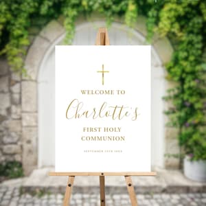 May include: White sign with a gold cross at the top and the text "Welcome to Charlotte's First Holy Communion September 19th 20XX".