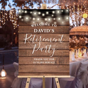 May include: A wooden welcome sign for David's Retirement Party, with string lights at the top. The sign reads "Welcome to David's Retirement Party" and "Thank you for 25 Years Service" in white script against a brown wood background.