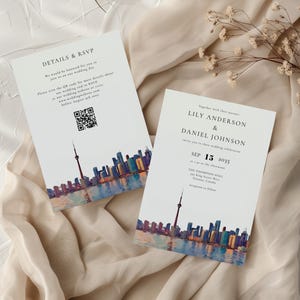 May include: Two white wedding invitation cards with a watercolor skyline design. The cards feature the names Lily Anderson and Daniel Johnson, with the date September 15, 2035. One card includes a QR code and RSVP details.