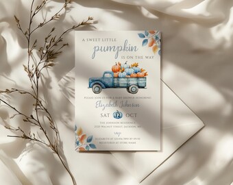 Può includere: Invito per baby shower con illustrazione ad acquerello di un camion blu che trasporta zucche. Il testo recita "A Sweet Little Pumpkin is on the Way" e include i dettagli dell'evento: data, ora e luogo.