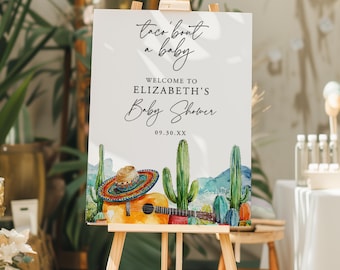 Puede incluir: Un letrero blanco sobre un caballete de madera con el texto "taco 'bout a baby" y "Welcome to Elizabeth's Baby Shower 09.30.XX". El letrero presenta una ilustración de acuarela de un sombrero, una guitarra y cactus.