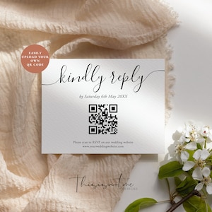 May include: A white card with black text that reads "kindly reply by Saturday 6th May 20XX". A black and white QR code is below the text. The text "Please scan to RSVP on our wedding website www.yourweddingwebsite.com" is below the QR code. The card is on a light brown fabric background.