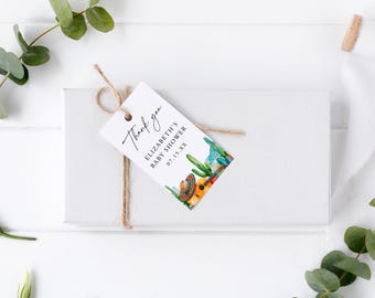 May include: A white gift box with a tag that says "Thank you" and "Elizabeth's Baby Shower 07.15.XX". The tag has a watercolor illustration of a guitar, cactus, and sombrero. The tag is tied with twine.
