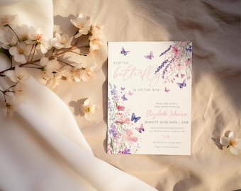 May include: A baby shower invitation with a floral and butterfly design. The invitation reads "A little butterfly is on the way!" in a delicate script. The design incorporates pink, purple, and blue butterflies and flowers, creating a soft, feminine aesthetic.