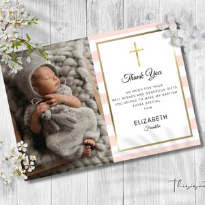 May include: Pink and white striped thank you card with a gold cross and gold border. The card has a photo of a baby girl sleeping in a knitted blanket. The text on the card reads: "Thank You So much for your well wishes and generous gifts, you helped to make my baptism extra special, Love Elizabeth Franklin"