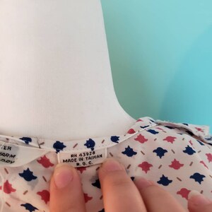 May include: A white blouse with a blue and red floral pattern. The tag reads "RN 43928 MADE IN TAIWAN R.O.C."