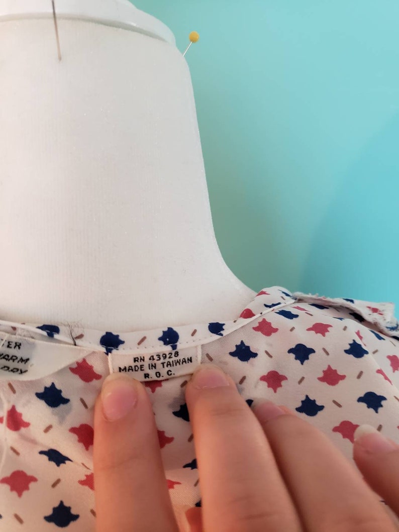 May include: A white blouse with a blue and red floral pattern. The tag reads "RN 43928 MADE IN TAIWAN R.O.C."