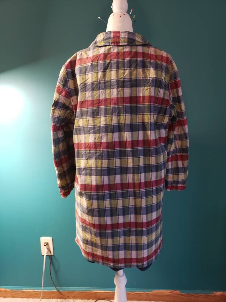 May include: A long-sleeved plaid shirt in shades of red, green, blue, and white. The shirt has a button-down collar and long sleeves.