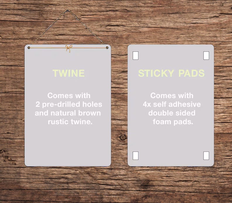 May include: Two rectangular, light gray signs with rounded corners are displayed against a wooden background. The left sign reads "TWINE" and includes text about pre-drilled holes and twine. The right sign reads "STICKY PADS" and includes text about self-adhesive foam pads.