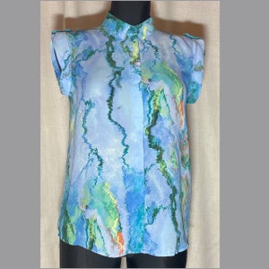 May include: A blue, green and yellow patterned blouse with a mandarin collar and short sleeves.