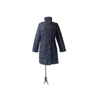 May include: A black and white checkered coat with a double-breasted closure and a high collar.