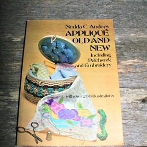 May include: A book titled "Appliqué Old and New" by Nedda C. Anders, featuring a vintage-style illustration of a sewing basket with fabric and needles, and a close-up of a floral appliqué design with colorful thread.