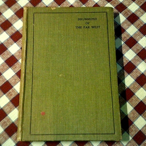 Peut inclure: Un livre vert avec le titre "Drummond of the Far West" sur la couverture.