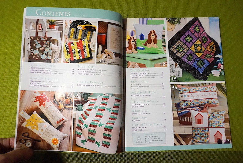 Puede incluir: P&aacute;gina doble abierta de una revista de manualidades. Muestra varios art&iacute;culos hechos a mano, incluyendo un bolso de mano, edredones, cojines con motivos de perros y casas, y una colcha de retazos. La p&aacute;gina de "Contenidos" es visible.