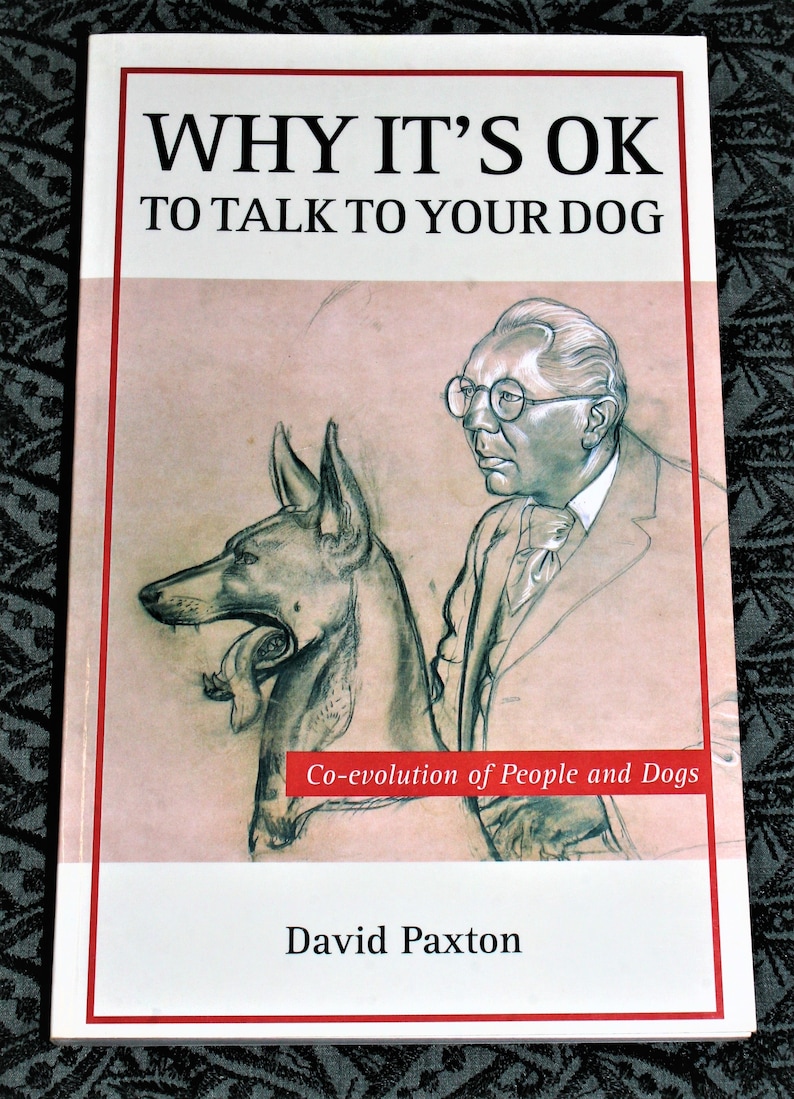 May include: Book cover with a black and white illustration of a dog and a man wearing glasses. The title of the book is "Why It's OK To Talk To Your Dog" and the subtitle is "Co-evolution of People and Dogs". The author's name is David Paxton.