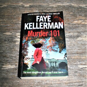 Könnte beinhalten: Ein Buchcover mit rotem Hintergrund und dem Titel "Faye Kellerman Mord 101" in weißer Schrift. Der Untertitel lautet "Die gefährlichste Lektion, die du jemals lernen wirst..." und das Cover zeigt eine Frau in einem roten Mantel, die von einem Gebäude weggeht.