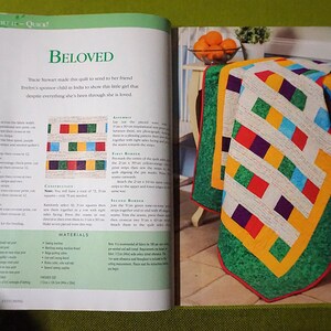 Puede incluir: Un edred&oacute;n colorido con un dise&ntilde;o geom&eacute;trico, con cuadrados rojos, azules, verdes y morados, sobre un fondo blanco. El edred&oacute;n est&aacute; bordeado con verde y amarillo. La palabra "Beloved" es visible en el libro abierto.