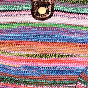 K&ouml;nnte beinhalten: Eine bunte gestreifte geh&auml;kelte Tasche mit einer braunen geh&auml;kelten Klappe und einem beigefarbenen Knopf.