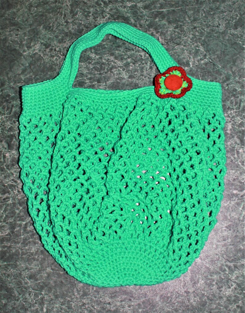 May include: A green crocheted mesh bag with a red and green flower embellishment.