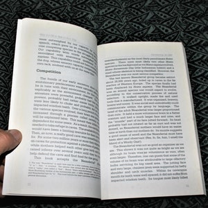 May include: Open book with a close-up of a page discussing the Neanderthal species. The text describes the Neanderthal's physical characteristics, including their brain size, facial features, and skull shape. The book also mentions the Neanderthal's extinction around 28,500 years ago.