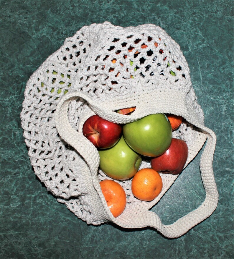 May include: A white crocheted mesh bag filled with red and green apples, and orange mandarins.