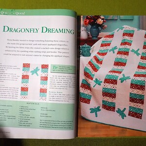 Puede incluir: Una p&aacute;gina de revista con un patr&oacute;n de edred&oacute;n titulado "Dragonfly Dreaming". El dise&ntilde;o del edred&oacute;n incluye rayas blancas, rojas y turquesas con aplicaciones de lib&eacute;lulas. La revista tambi&eacute;n muestra un edred&oacute;n terminado sobre una silla.