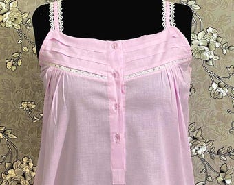 May include: A light pink sleeveless nightgown with white lace trim and a button-up front.