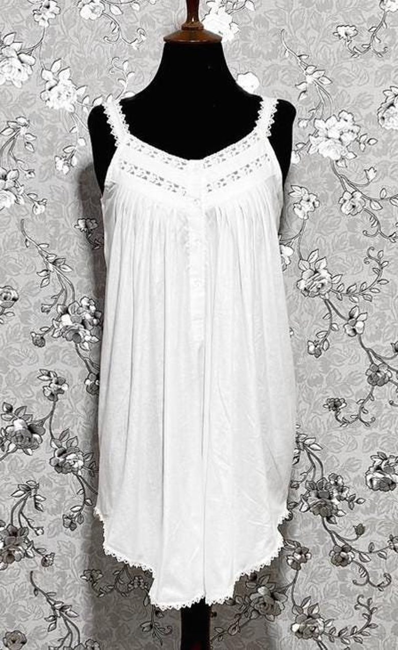 Peut inclure: Une chemise de nuit en coton blanc avec des bordures en dentelle et un devant boutonn&eacute;.