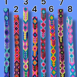 May include: Eight woven friendship bracelets arranged vertically and numbered one through eight. Each bracelet features a unique, intricate geometric pattern created with vibrant, multi-colored thread including shades of pink, blue, yellow, and black.